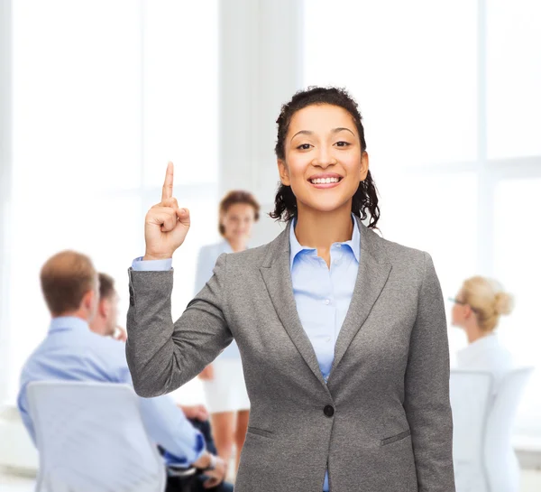 Lächelnde Geschäftsfrau mit erhobenem Finger im Büro — Stockfoto