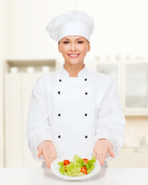 Chef feminino sorridente com salada no prato — Fotografia de Stock