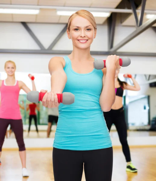 Jeune femme sportive avec haltères légers — Photo