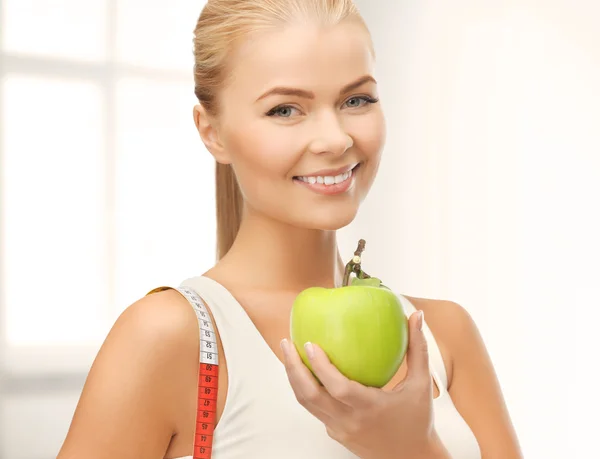 Sportiga kvinnan med äpple och måttband — Stockfoto
