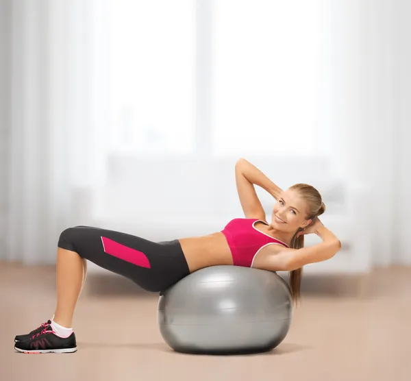 Mujer sonriente con pelota de fitness en casa —  Fotos de Stock