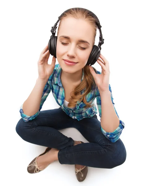 Jonge vrouw listeting naar muziek met een hoofdtelefoon — Stockfoto