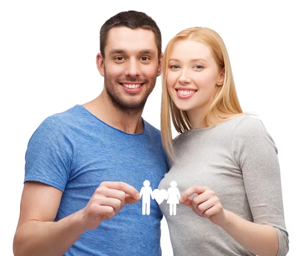 Smiling coule holding paper family with heart — Stock Photo, Image