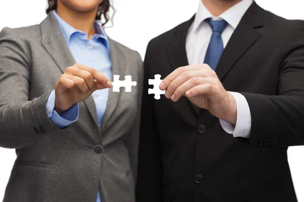 Businessman and businesswoman with puzzle pieces — Stock Photo, Image