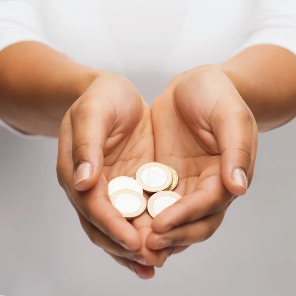 Mãos de xícara de mulher mostrando moedas de euro — Fotografia de Stock