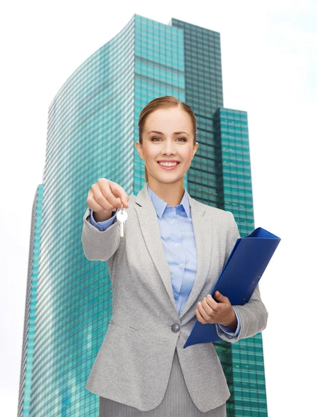 Mujer de negocios sonriente con carpeta y llaves — Foto de Stock