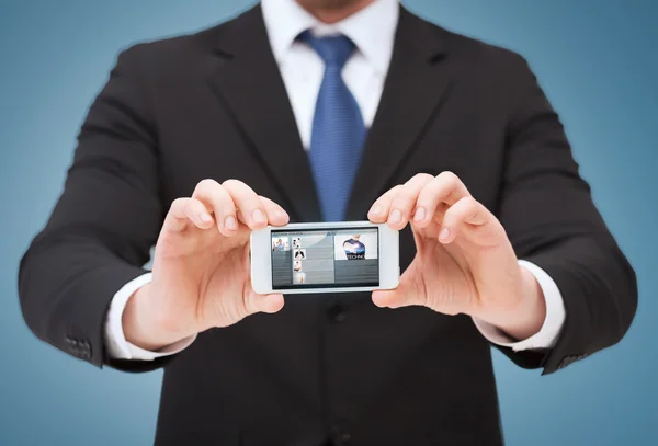 Geschäftsmann zeigt Smartphone mit leerem Bildschirm — Stockfoto