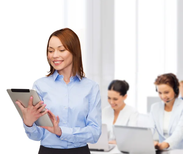 Lächelnde Frau blickt im Büro auf Tablet-PC — Stockfoto