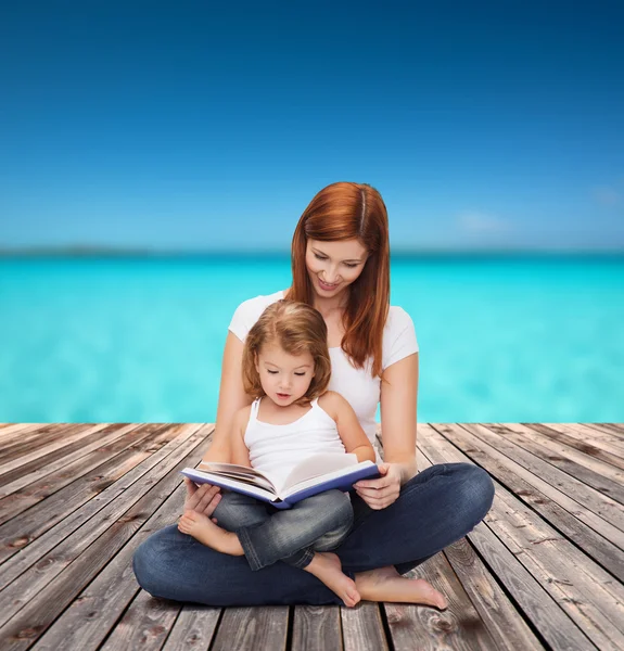 Glückliche Mutter mit entzückendem kleinen Mädchen und Buch — Stockfoto