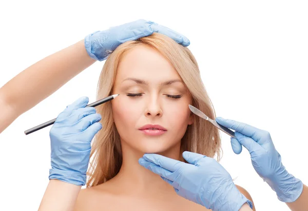 Woman and beautician hands with pencil and scalpel — Stock Photo, Image