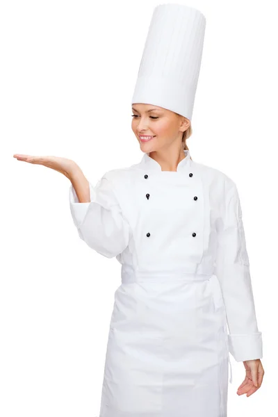 Sorrindo chef feminino segurando algo na mão — Fotografia de Stock