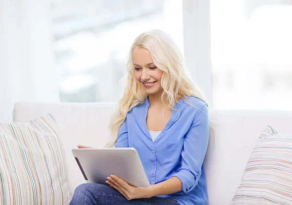 Leende kvinna med tablet pc-dator hemma — Stockfoto