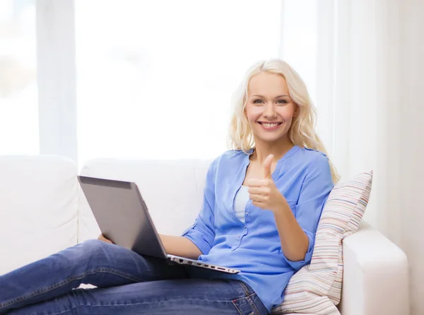 Usmívající se žena s přenosným počítačem doma — Stock fotografie