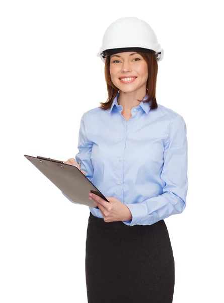 Smiling businesswoman in helmet with clipboard Stock Picture