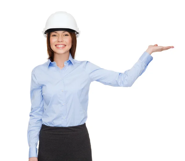 Geschäftsfrau mit Helm hält etwas auf Handfläche Stockbild