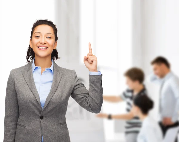 Lächelnde Geschäftsfrau mit erhobenem Finger im Büro — Stockfoto
