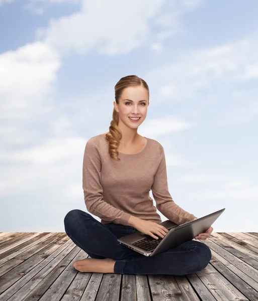 Genç bir kadın dizüstü bilgisayarla yerde oturuyor. — Stok fotoğraf