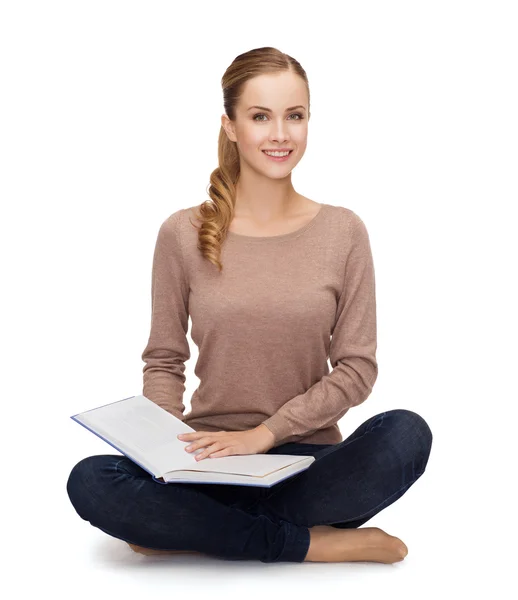 Smiling young woman sitting on floor — Stock Photo, Image