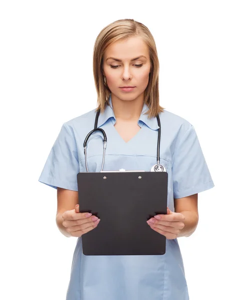 Улыбающаяся женщина-врач или медсестра с планшетом — стоковое фото