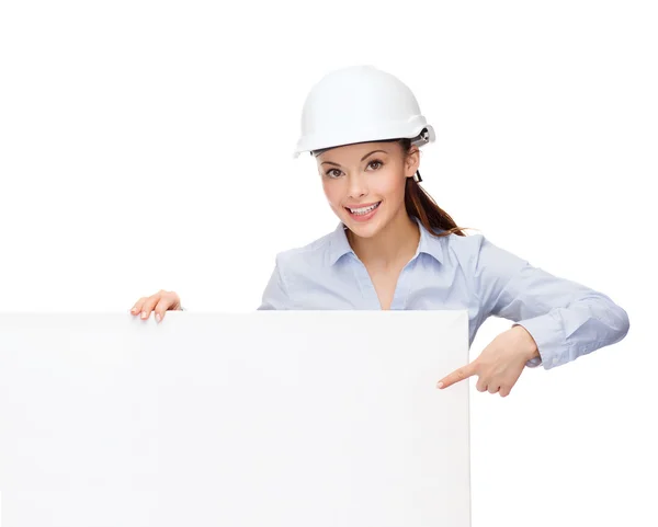 Businesswoman in helmet pointing finger to board — Stock Photo, Image