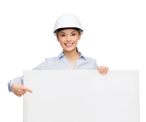 Businesswoman in helmet pointing finger to board — Stock Photo, Image
