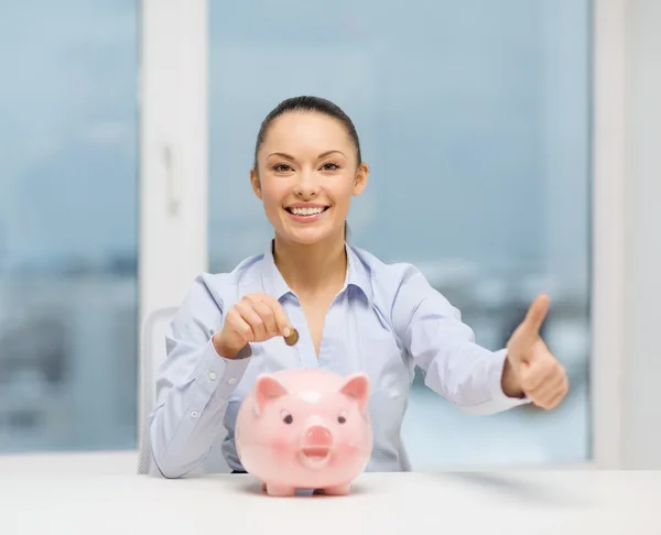 Mulher sorridente com banco porquinho e dinheiro em dinheiro — Fotografia de Stock