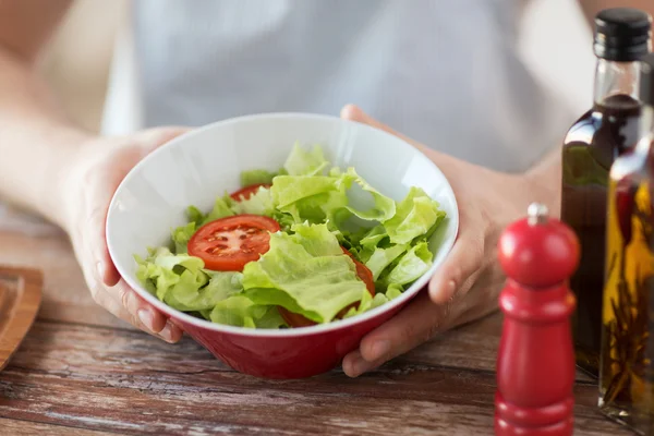 Fechar da mão masculina segurando uma tigela com salada — Fotografia de Stock