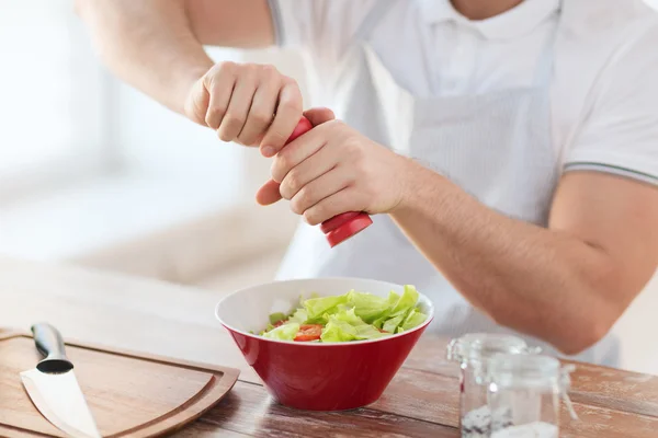 Close up of male hands flavouring salad in a bowl — Stock Photo, Image