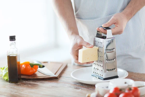 Close up of male hands grating cheese — Stock Photo, Image