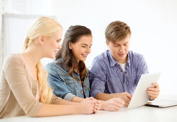 Usmívající se studenti s počítačem tablet pc ve škole — Stock fotografie