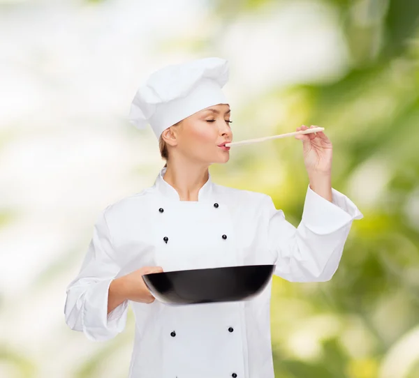 Chef feminino sorridente com panela e colher — Fotografia de Stock