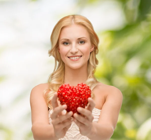 Femme souriante donnant petit coeur rouge — Photo