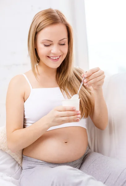 Happy pregnant woman with yogurt — Stock Photo, Image