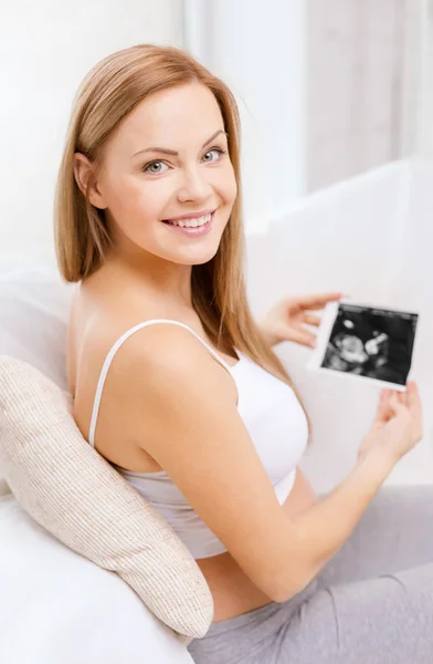 Счастливая беременная женщина с ультразвуковой картиной — стоковое фото