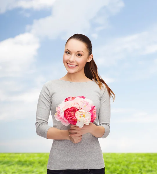 Ung kvinna med bukett blommor — Stockfoto