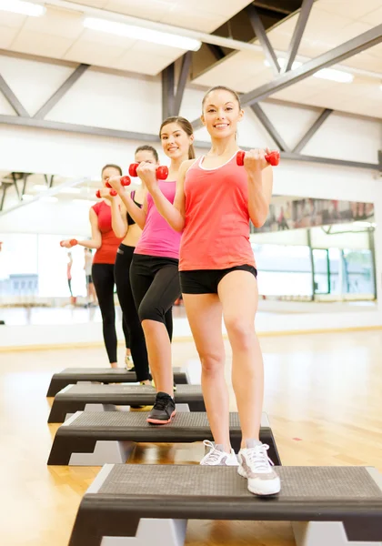 Gruppe lächelnder Frauen mit Hanteln und Step — Stockfoto