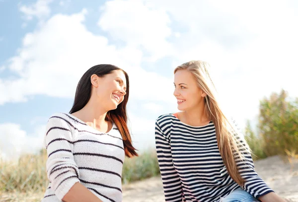 Lächelnde Freundinnen, die Spaß am Strand haben — Stockfoto