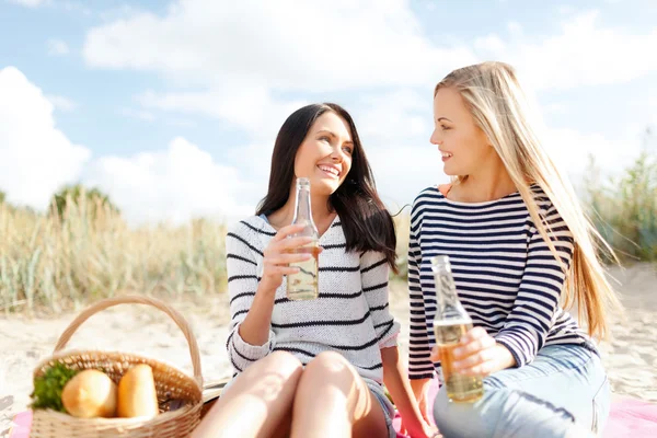 Namoradas com garrafas de cerveja na praia — Fotografia de Stock
