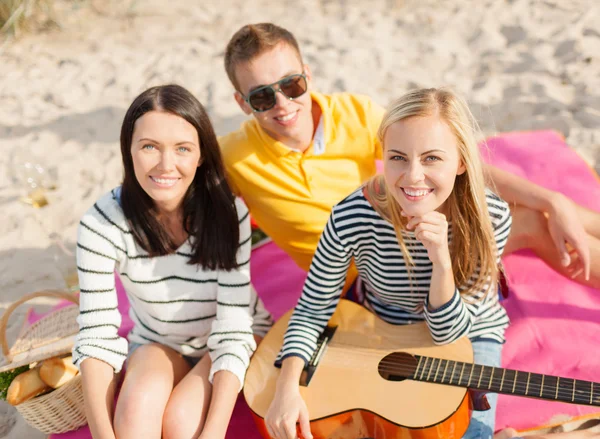 Groep vrienden met gitaar plezier op strand — Stockfoto