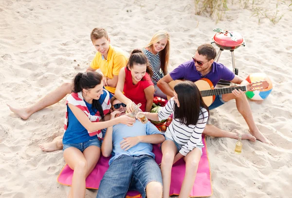 Groep vrienden met gitaar plezier op strand — Stockfoto