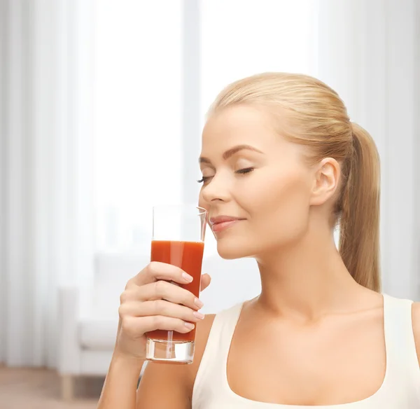 Jovem mulher bebendo suco de tomate — Fotografia de Stock