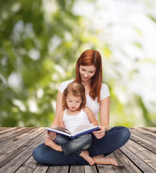 Sevimli küçük kız ve kitap ile mutlu anne — Stok fotoğraf