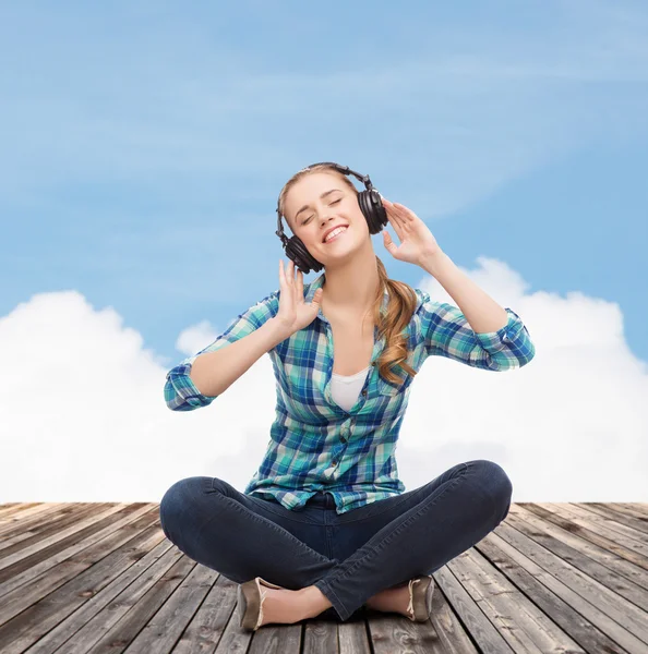 Junge Frau hört Musik mit Kopfhörern — Stockfoto