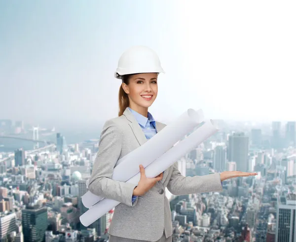 Arquitecto sonriente en casco blanco con planos —  Fotos de Stock