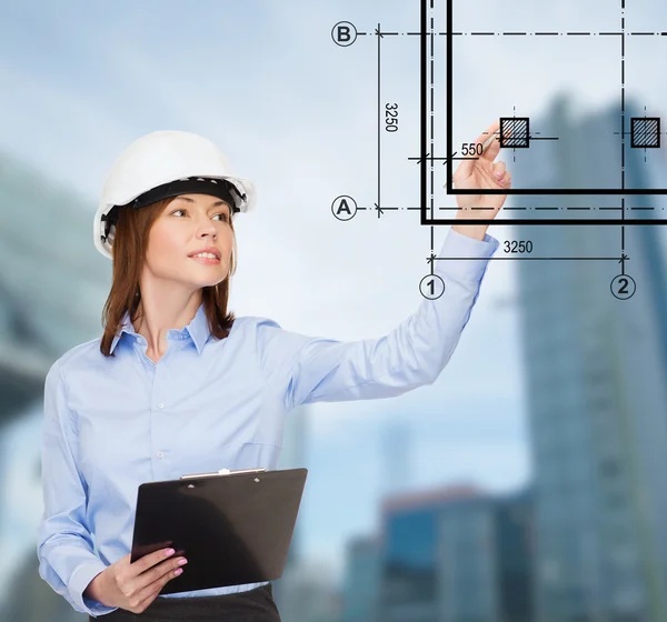 Smiling businesswoman in helmet with clipboard — Stock Photo, Image