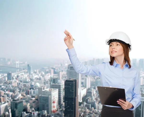 Mujer de negocios sonriente en casco con portapapeles —  Fotos de Stock