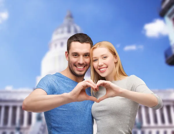 Couple souriant montrant le cœur avec les mains — Photo