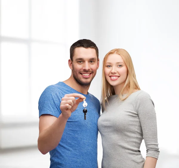 Pareja sonriente sosteniendo llaves —  Fotos de Stock