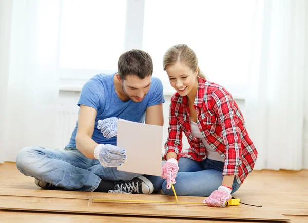 Smiling couple measuring wood flooring — Stock Photo, Image