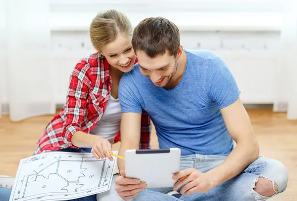 Lachende paar kijken naar tablet pc thuis — Stockfoto